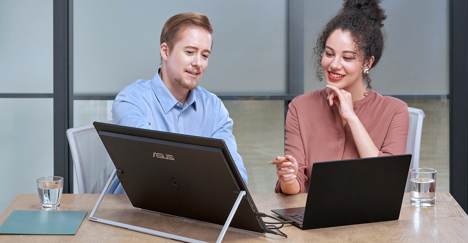 Colleagues discuss in a share office using laptop and ZenScreen MB249C