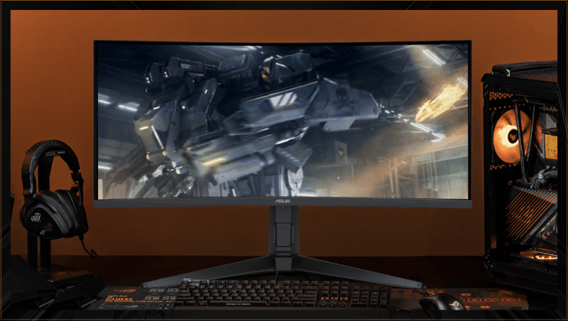 A VG34WQL5A monitor centered in frame, with a keyboard positioned in front, headphones to the left, and a computer tower to the right.
