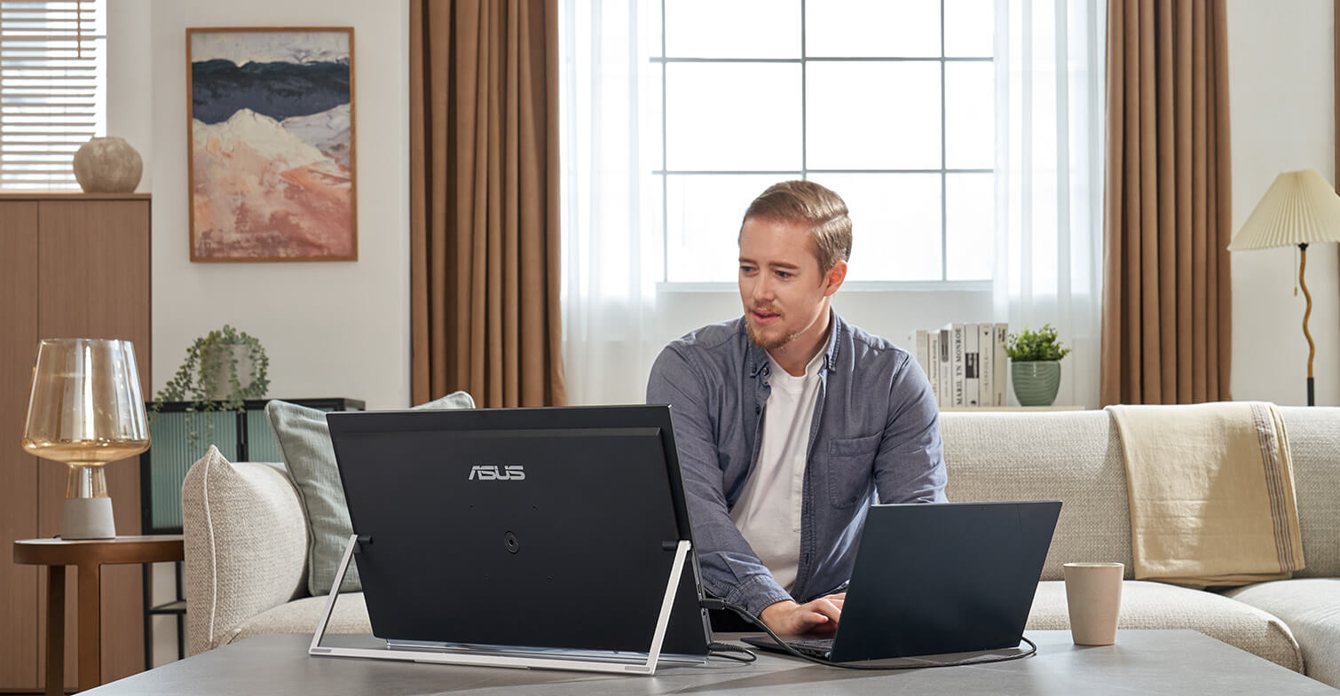 Front view of a man works from home using ZenScreen MB249C in kickstand mode at lower cafe table